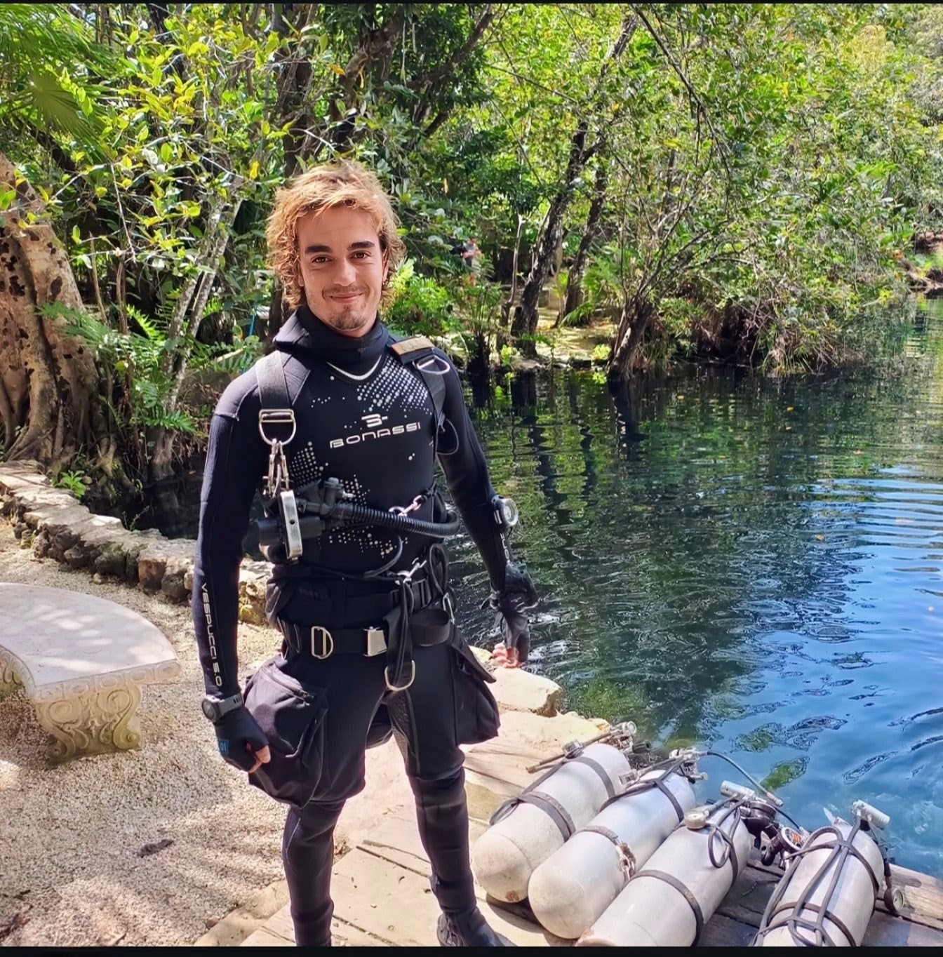 Zalo beside scuba tanks at a cenote